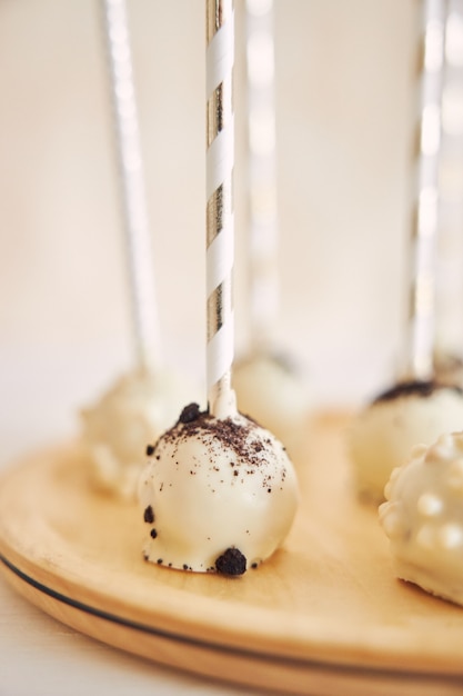 Foto grátis tiro vertical de delicioso bolo branco aparece na mesa branca e de madeira