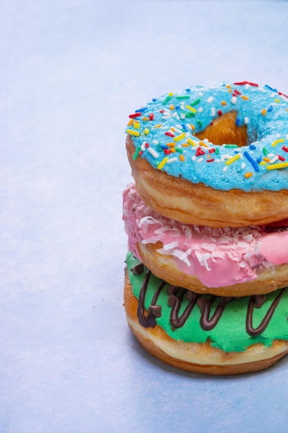 Tiro vertical de donut colorido sobre fundo azul
