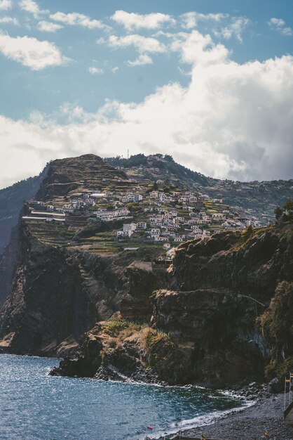 Tiro vertical de edifícios na montanha sob um céu azul no Funchal, Madeira, Portugal.