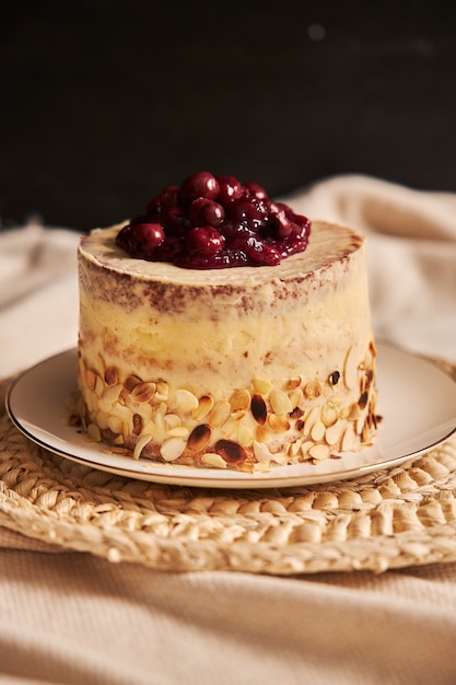 Tiro vertical de um bolo de cereja com creme no prato branco