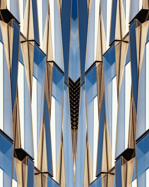 Tiro vertical de um edifício simétrico de vidro e concreto azul