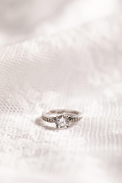 Tiro vertical de um lindo anel de diamante em uma superfície branca