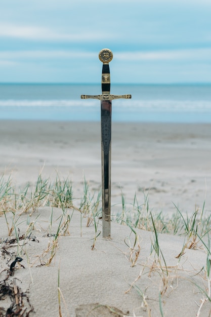 Tiro vertical de uma espada na praia