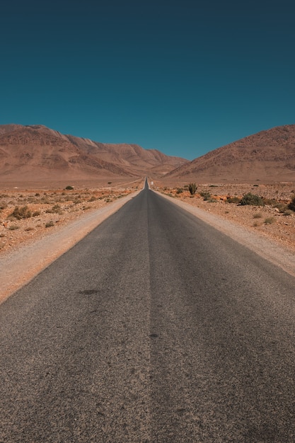 Tiro vertical de uma estrada no meio do deserto e montanhas capturadas em Marrocos