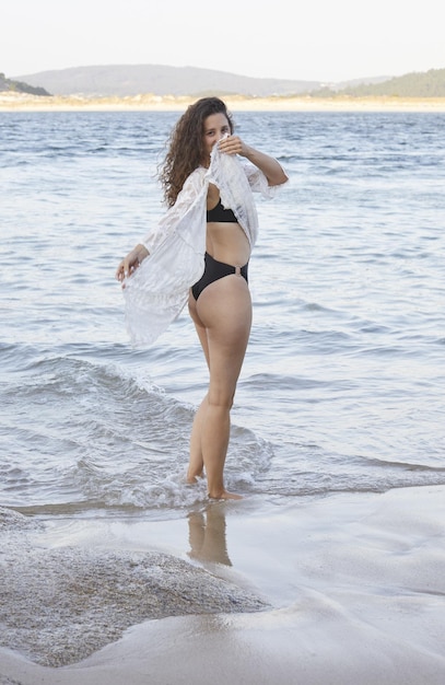 Tiro vertical de uma mulher atraente caucasiana em uma praia na espanha