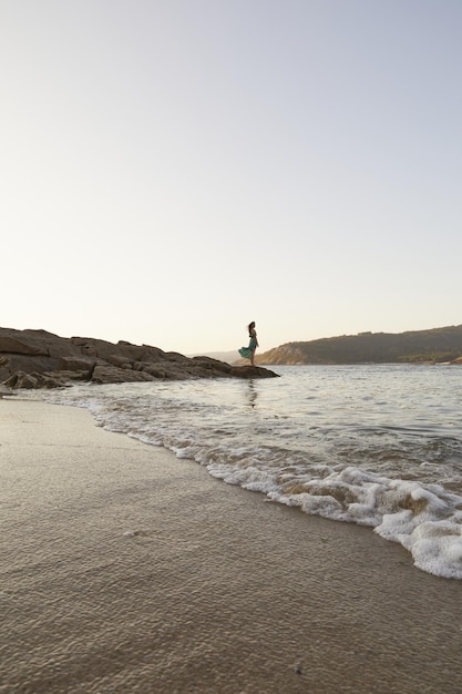Tiro vertical de uma mulher atraente caucasiana em uma praia na Espanha