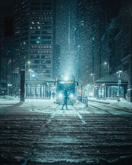 Tiro vertical de uma pessoa na frente de um trem em uma estrada com neve