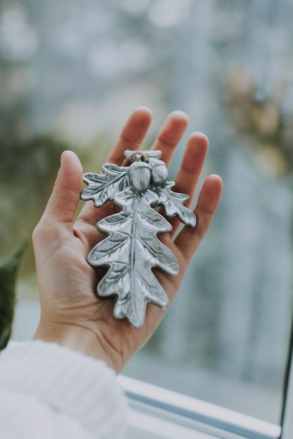 Tiro vertical de uma pessoa segurando um enfeite de árvore de natal