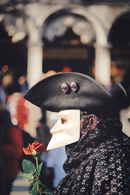 Tiro vertical do homem com uma bauta, máscara típica de carnaval veneziano