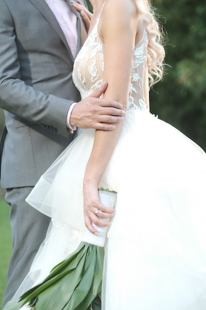 Tiro vertical do noivo e da noiva posando para um photoshoot de casamento romântico