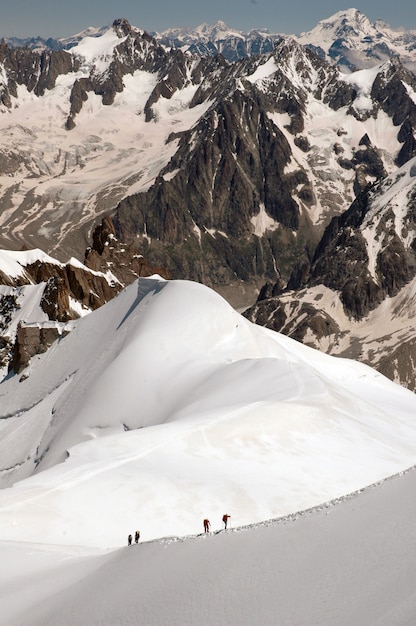 Tiro vertical dos magníficos picos das montanhas cobertas de neve