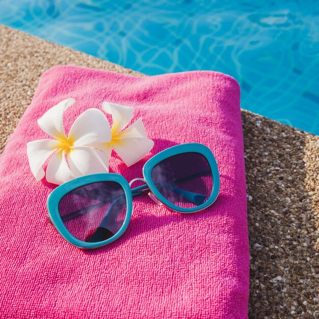 Toalha cor-de-rosa com óculos de sol azuis