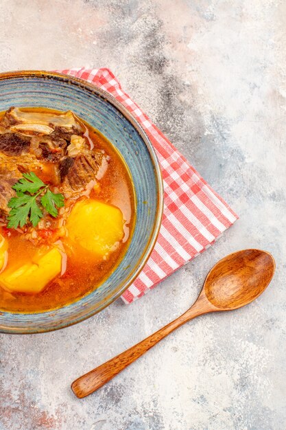 Toalha de cozinha de sopa bozbash de vista frontal uma colher de pau em cozinha azerbaijana nua