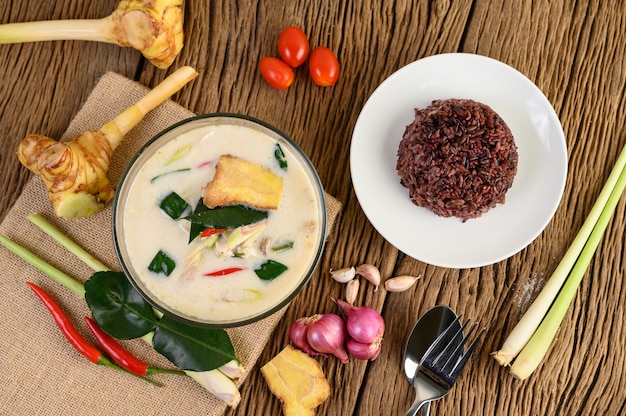 Foto grátis tom kha kai em uma tigela com folhas de limão kaffir, erva-cidreira, cebola roxa, galanga e pimenta.