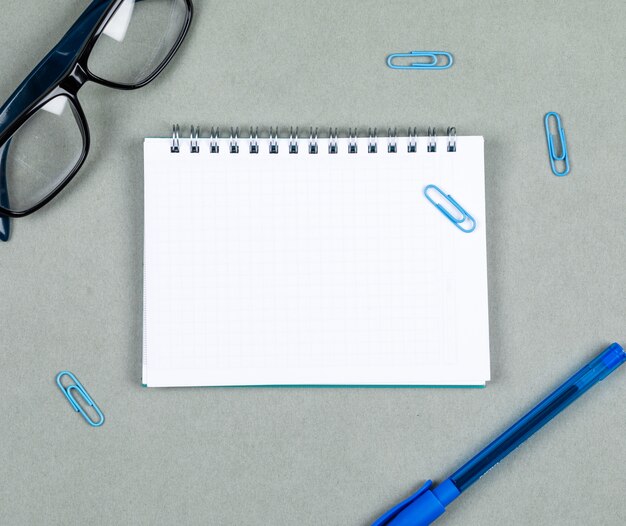 Tomando notas conceito com caderno, caneta, óculos na vista superior do plano de fundo cinza. espaço para texto. imagem horizontal