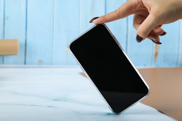 Tomando um celular preto com um dedo