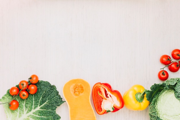 Tomate cereja fresco; repolho; pimentão e polpa de butternut na superfície de madeira