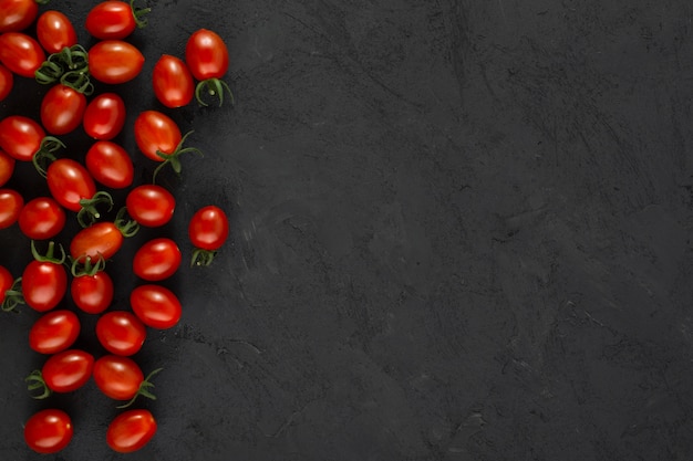 Tomate cereja vermelho maduro fresco em fundo cinza