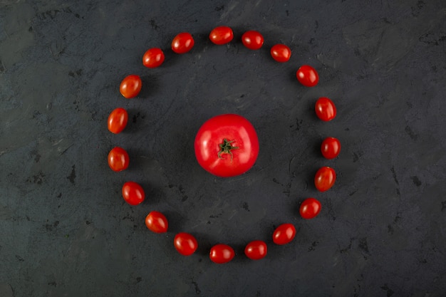 Foto grátis tomate cereja vermelho tomate maduro na mesa cinza