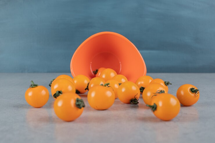 Foto grátis tomates amarelos isolados na superfície da pedra