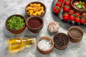 Foto grátis tomates cereja frescos de vista frontal dentro do prato com diferentes temperos na superfície branca salada de comida de refeição de vegetais