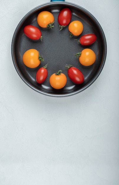 Foto grátis tomates coloridos dentro de uma panela em fundo branco. foto de alta qualidade