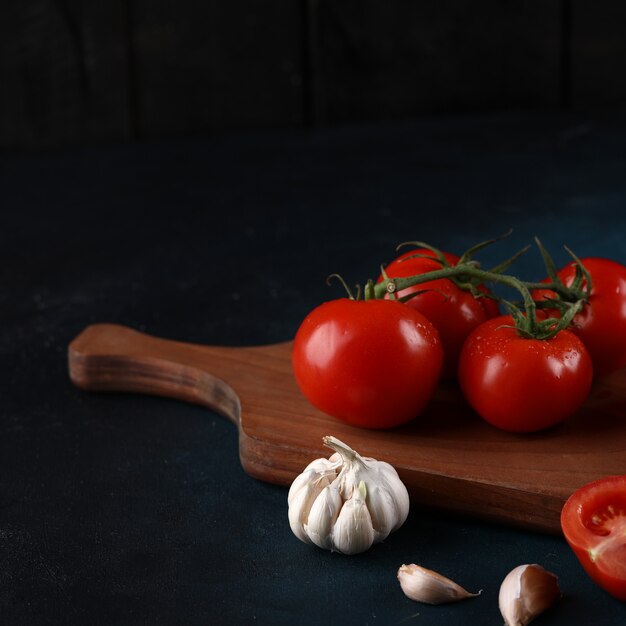 Tomates e alhos sobre um fundo azul.