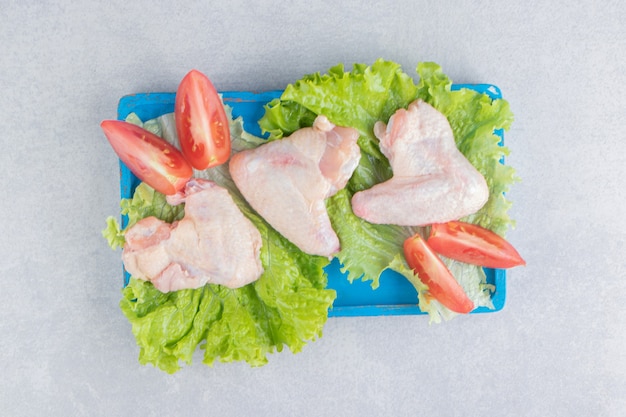 Foto grátis tomates fatiados e carne na alface, no quadro, na superfície branca