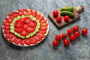 Foto grátis tomates frescos fatiados de frente para salada com design elegante em espaço rústico cinza