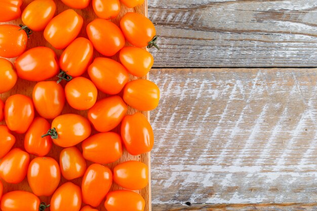 Tomates na tábua de madeira e corte. configuração plana.