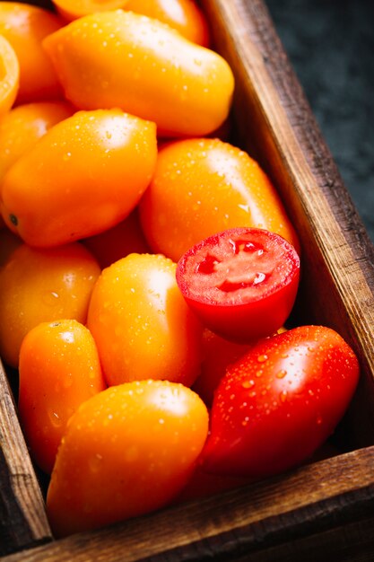 Tomates pequenos alaranjados e vermelhos do close-up