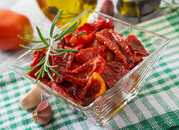 Tomates secos ao sol com ervas e alho em uma tigela de madeira