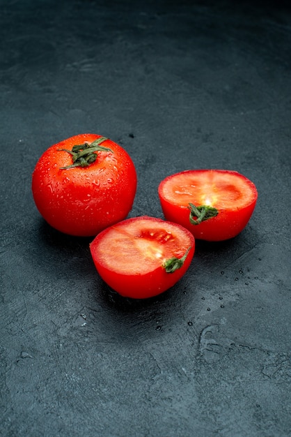 Tomates vermelhos cortados ao meio em mesa preta de copa