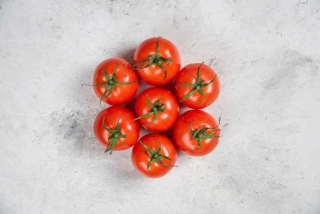 Tomates vermelhos frescos em um fundo de mármore