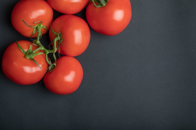 Tomates vermelhos maduros na superfície escura