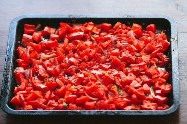 Tomates vermelhos picados com ervas em uma panela preta