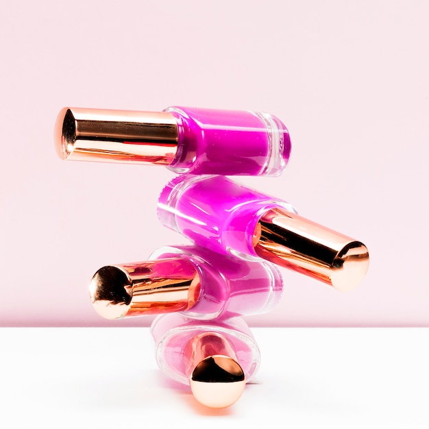Foto grátis tons rosa de garrafa de esmalte de unha empilhada