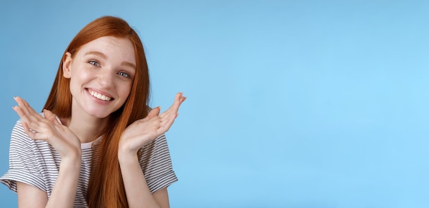 Foto grátis tonto, bonito, sincero, jovem europeu, garota vermelha, olhos azuis, encolhendo os ombros, segurando as mãos, duvidosamente espalhada perto.