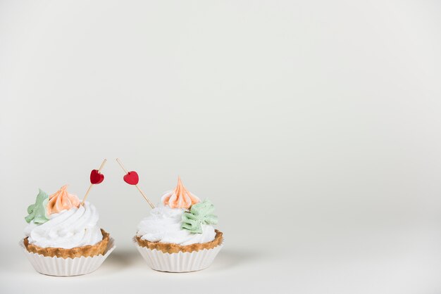 Toppers de coração em dois bolinhos na mesa