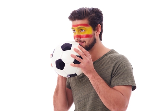 Foto grátis torcedor de futebol nervoso com bola de futebol olhando para frente
