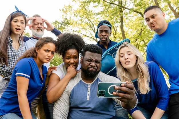 Foto grátis torcedores de beisebol assistindo seu time perder o jogo em um telefone