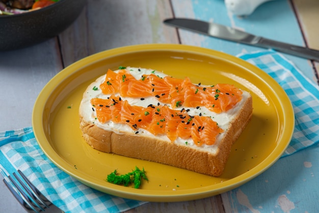 Torrada com salmão defumado e cream cheese na mesa de madeira