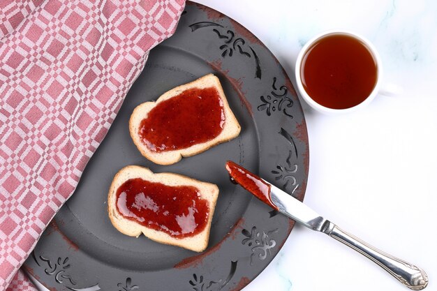 Torradas com geléia de morango e uma xícara de chá