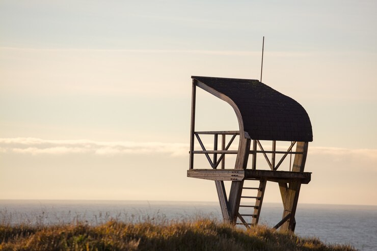 Foto grátis torre do salva-vidas em um campo cercado pelo mar sob um céu nublado à noite