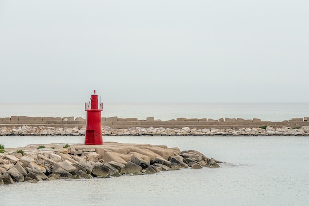 Torre vermelha perto da praia sob um céu azul claro