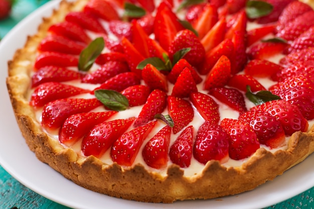 Torta com morangos e chantilly decorado com folhas de hortelã.