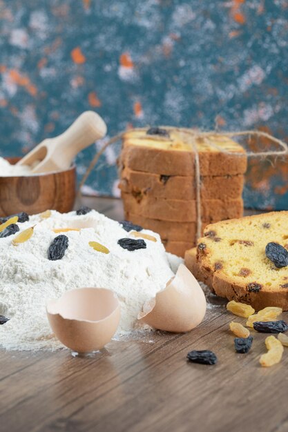 Torta de sultana com ingredientes no deck de madeira.