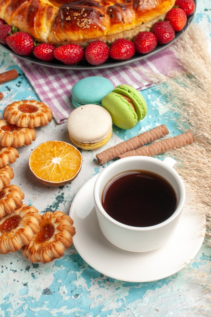 Foto grátis torta doce gostosa de vista frontal com biscoitos de morangos vermelhos e chá na superfície azul