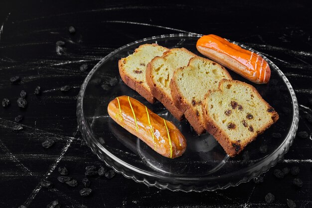 Torta fatiada em uma travessa de vidro com eclairs.