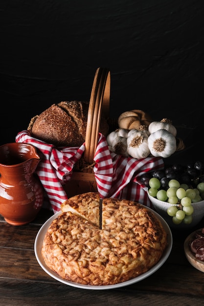 Torta perto de jarro e cesta com comida